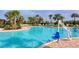 Beautiful community pool area with accessibility lift, surrounded by palm trees and lounge chairs at 364 Grande Vista Blvd, Bradenton, FL 34212