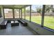 Enclosed porch with decorative floor, wooden benches, and views of landscaped yard at 3730 Ferguson St, Sarasota, FL 34233