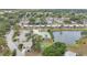 Sprawling residential community featuring well-maintained homes, community pool, and scenic pond from above at 3816 Blue Stone Way # 97, Sarasota, FL 34232