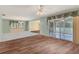 Open living room featuring laminate flooring and large slider leading to a bright sunroom at 3816 Blue Stone Way # 97, Sarasota, FL 34232