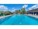 Community pool with clear blue water, lounge chairs, and lush green landscaping at 3816 Blue Stone Way # 97, Sarasota, FL 34232