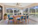 Bright sunroom featuring floor-to-ceiling windows and a wooden table with six blue upholstered chairs at 3816 Blue Stone Way # 97, Sarasota, FL 34232