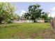 Sprawling backyard with lush green grass, mature trees, and a shed, perfect for outdoor activities and relaxation at 4015 Asbury Pl, Sarasota, FL 34233