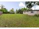Expansive backyard featuring lush green grass and mature trees, providing a serene outdoor space at 4015 Asbury Pl, Sarasota, FL 34233
