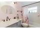 Charming bathroom with a light gray vanity, black hardware, and a shower-tub combination featuring a floral curtain at 4015 Asbury Pl, Sarasota, FL 34233