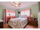 Bedroom with light-green walls, wood floors and pink sheer curtains at 4015 Asbury Pl, Sarasota, FL 34233
