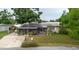 View of the front of the house with solar panels and screened porch with lush landscaping at 4015 Asbury Pl, Sarasota, FL 34233