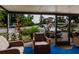 Inviting screened-in porch with comfortable seating, a garden view, and blue carpet at 4015 Asbury Pl, Sarasota, FL 34233