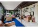 Relaxing screened-in porch featuring tiled flooring, blue carpet, chairs, and outdoor decor at 4015 Asbury Pl, Sarasota, FL 34233