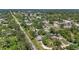 Expansive aerial view of the property and neighborhood surrounded by lush greenery, roads, and houses at 4251 Austin St, Sarasota, FL 34233