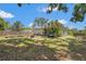 Serene backyard setting with a fire pit, surrounded by mature trees and a well-maintained lawn at 4251 Austin St, Sarasota, FL 34233