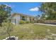 Quaint single-Gathering home with well-kept lawn, wrought iron fence and long driveway leading to an attached garage at 4251 Austin St, Sarasota, FL 34233