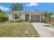 Single-story home featuring a well-maintained lawn and a long driveway leading to a one car garage at 4251 Austin St, Sarasota, FL 34233