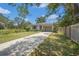 Single-story home with a manicured lawn, fenced yard, and a concrete driveway leading to a one car garage at 4251 Austin St, Sarasota, FL 34233