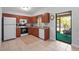Well-lit kitchen with wooden cabinetry, white appliances and a view of the screened lanai at 4251 Austin St, Sarasota, FL 34233