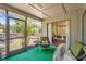 Bright sunroom with wicker chairs and green carpet, extending to the lush outdoors through a screened entrance at 4251 Austin St, Sarasota, FL 34233