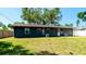 View of home exterior and a sprawling backyard with mature trees and an air conditioner at 4310 7Th W Ave, Bradenton, FL 34209