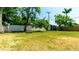 Large backyard with mature trees, fire pit, white fencing and storage shed at 4310 7Th W Ave, Bradenton, FL 34209