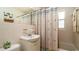 Bright bathroom featuring a white vanity, toilet, and a shower with a pineapple-themed curtain at 4310 7Th W Ave, Bradenton, FL 34209