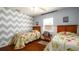 Charming bedroom with twin beds, unique chevron wall pattern, and cozy decor at 4310 7Th W Ave, Bradenton, FL 34209