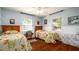 Inviting bedroom with two twin beds, wood floors, and ample natural light, perfect for guests at 4310 7Th W Ave, Bradenton, FL 34209