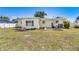 Backyard with small garden beds, mature trees, and a well-maintained lawn at 4375 Tortoise Rd, Venice, FL 34293
