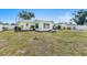 Backyard with garden beds, white fence, mature trees, and green lawn at 4375 Tortoise Rd, Venice, FL 34293
