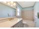 Bright bathroom with light blue walls, tile shower, marble countertop and decorative wallpaper at 4375 Tortoise Rd, Venice, FL 34293