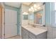 Bathroom with light blue walls, tile shower, marble countertop and decorative wallpaper at 4375 Tortoise Rd, Venice, FL 34293