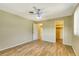 Neutral bedroom with ceiling fan, wood-look floors, walk-in closet, and painted beige walls at 4375 Tortoise Rd, Venice, FL 34293