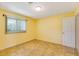 Inviting bedroom with yellow walls, tiled floors and a window with sun-blocking vertical blinds at 4375 Tortoise Rd, Venice, FL 34293