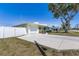 Exterior view of the house featuring a concrete driveway and white fenced-in yard at 4375 Tortoise Rd, Venice, FL 34293