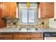 Kitchen featuring stainless steel sink, granite countertops, and wood cabinets at 4375 Tortoise Rd, Venice, FL 34293