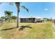 Wide backyard featuring a screened-in patio and views of mature palm trees at 4535 Maceachen Blvd, Sarasota, FL 34233