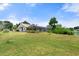 Expansive backyard showcasing a well-maintained lawn, mature landscaping, and a screened-in pool enclosure at 4622 34Th E Ct, Bradenton, FL 34203