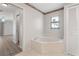 Bathroom featuring large soaking tub with marble surround, floral details, and closet at 4622 34Th E Ct, Bradenton, FL 34203