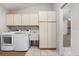 Bright laundry room featuring tile floors, white cabinetry, utility sink, and modern washer and dryer at 4622 34Th E Ct, Bradenton, FL 34203