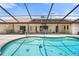 Sparkling pool with attached spa, surrounded by a screened enclosure and a covered patio with outdoor seating at 4622 34Th E Ct, Bradenton, FL 34203