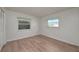 Bedroom featuring new laminate flooring, neutral paint, two windows and updated baseboards at 478 Orange Nw Dr, Port Charlotte, FL 33952