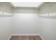 Walk-in closet with wood laminate flooring, white paint, and shelf and bar hanging system at 478 Orange Nw Dr, Port Charlotte, FL 33952