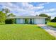 Charming single-story home with a well-manicured lawn and attached one car garage at 478 Orange Nw Dr, Port Charlotte, FL 33952