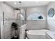 This bathroom features a soaking tub under an arched window with a tiled stand-up shower at 4844 14Th E Ave, Bradenton, FL 34208