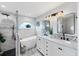 Bright bathroom featuring a soaking tub under an arched window and a double sink vanity with modern fixtures at 4844 14Th E Ave, Bradenton, FL 34208