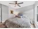 Comfortable bedroom showcasing a floral-patterned bedspread, a tufted headboard, and a ceiling fan at 4844 14Th E Ave, Bradenton, FL 34208