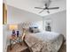 This cozy bedroom features a floral-patterned bedspread, a tufted headboard, and a ceiling fan at 4844 14Th E Ave, Bradenton, FL 34208