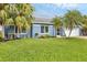 Beautiful well-maintained lawn, landscaping, and palm trees accent this stunning home exterior at 4844 14Th E Ave, Bradenton, FL 34208