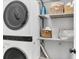 Efficient laundry area with stacked washer and dryer, and shelving for storage at 4844 14Th E Ave, Bradenton, FL 34208