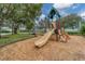 View of a community playground with a slide, climbing equipment, swings, and green spaces at 4844 14Th E Ave, Bradenton, FL 34208