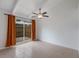 Neutral bedroom with tile flooring, neutral walls, ceiling fan, and sliding glass doors to the backyard at 500 N Jefferson Ave # G5, Sarasota, FL 34237
