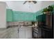Bright kitchen features stainless steel appliances, granite countertops, and stylish turquoise cabinets at 500 N Jefferson Ave # G5, Sarasota, FL 34237